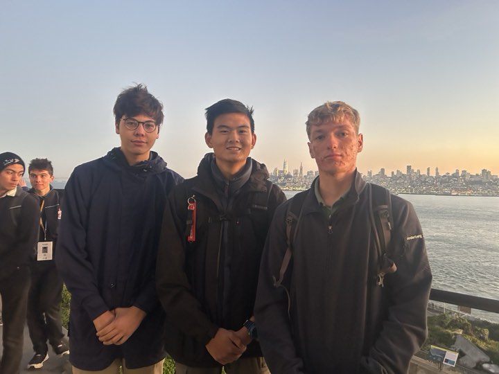 Friends at a lookout, the San Francisco skyline glowing at sunset