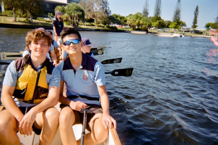 Jun and a teammate at the bow after the race, calm water, on film