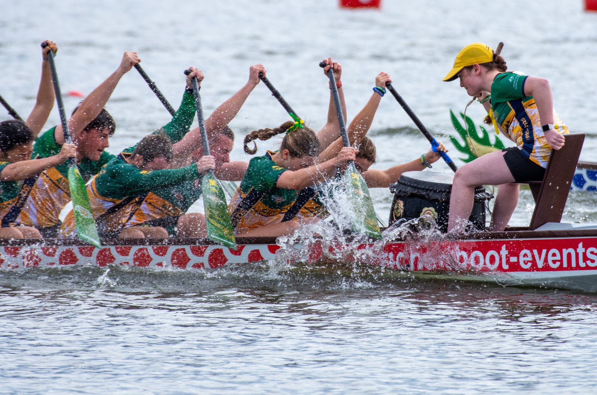 Close-up of paddlers mid-stroke, water flying