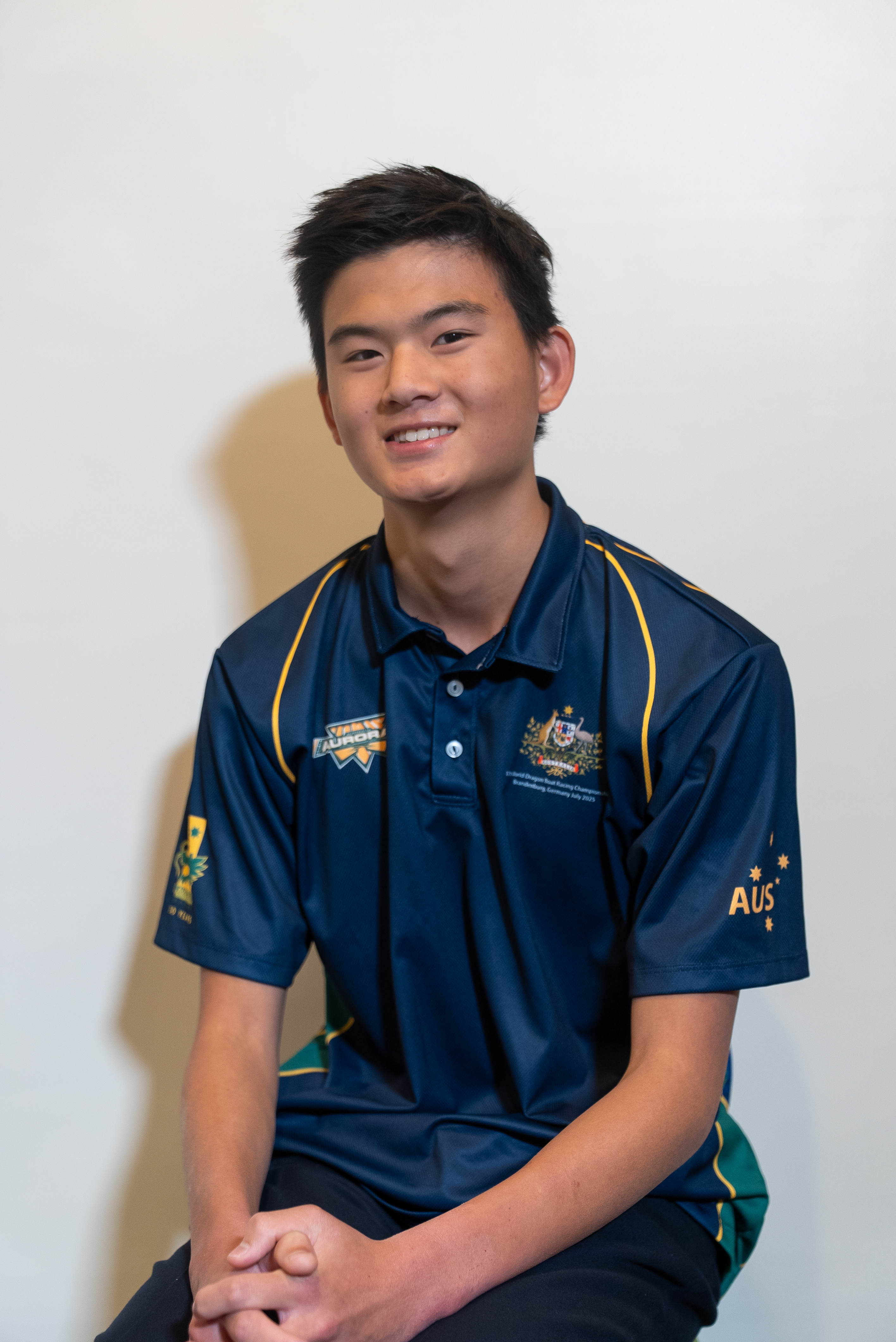 Jun's Australian team photo β smiling in his navy polo