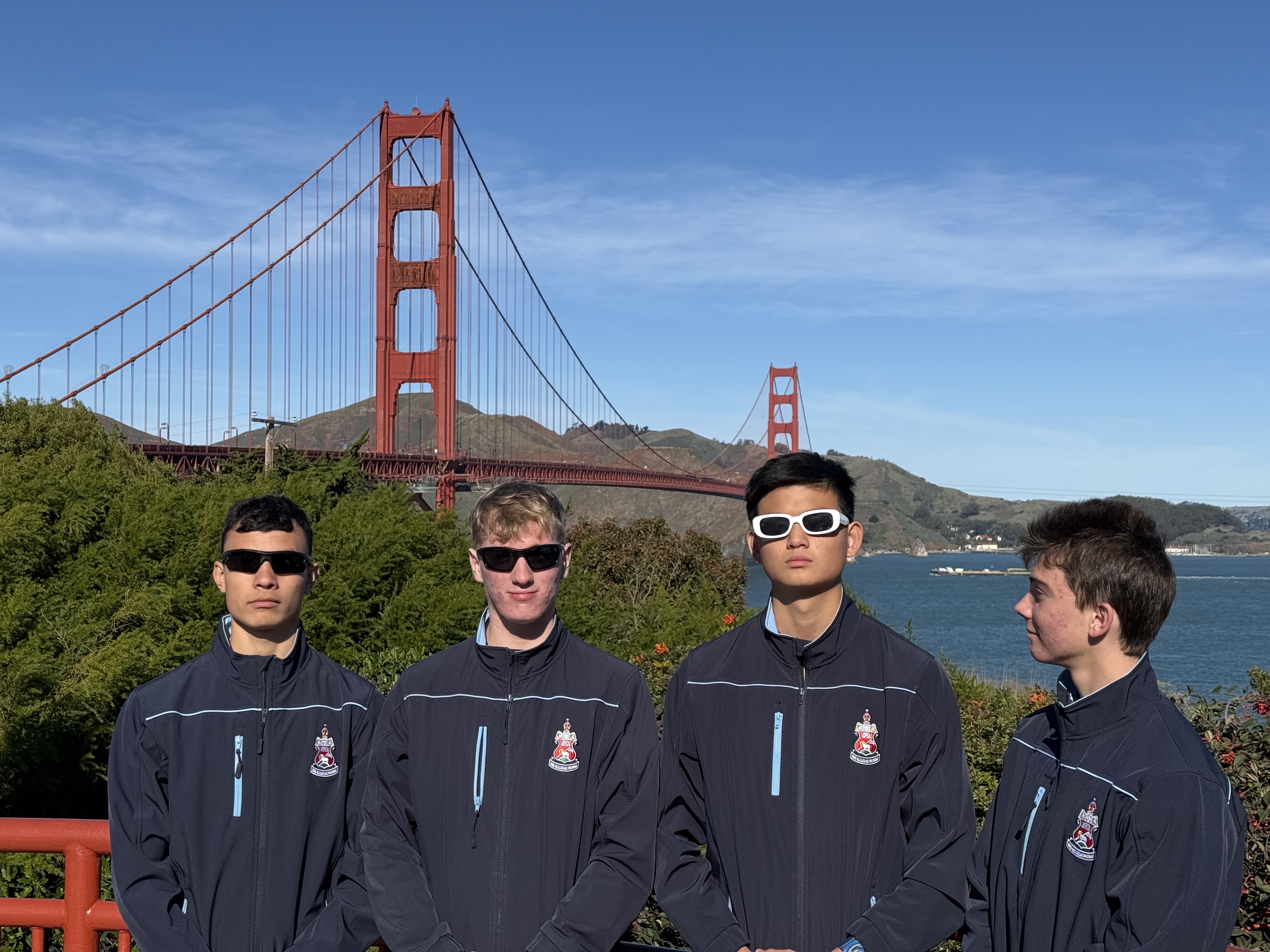 Four guys in school jackets, Golden Gate Bridge behind them