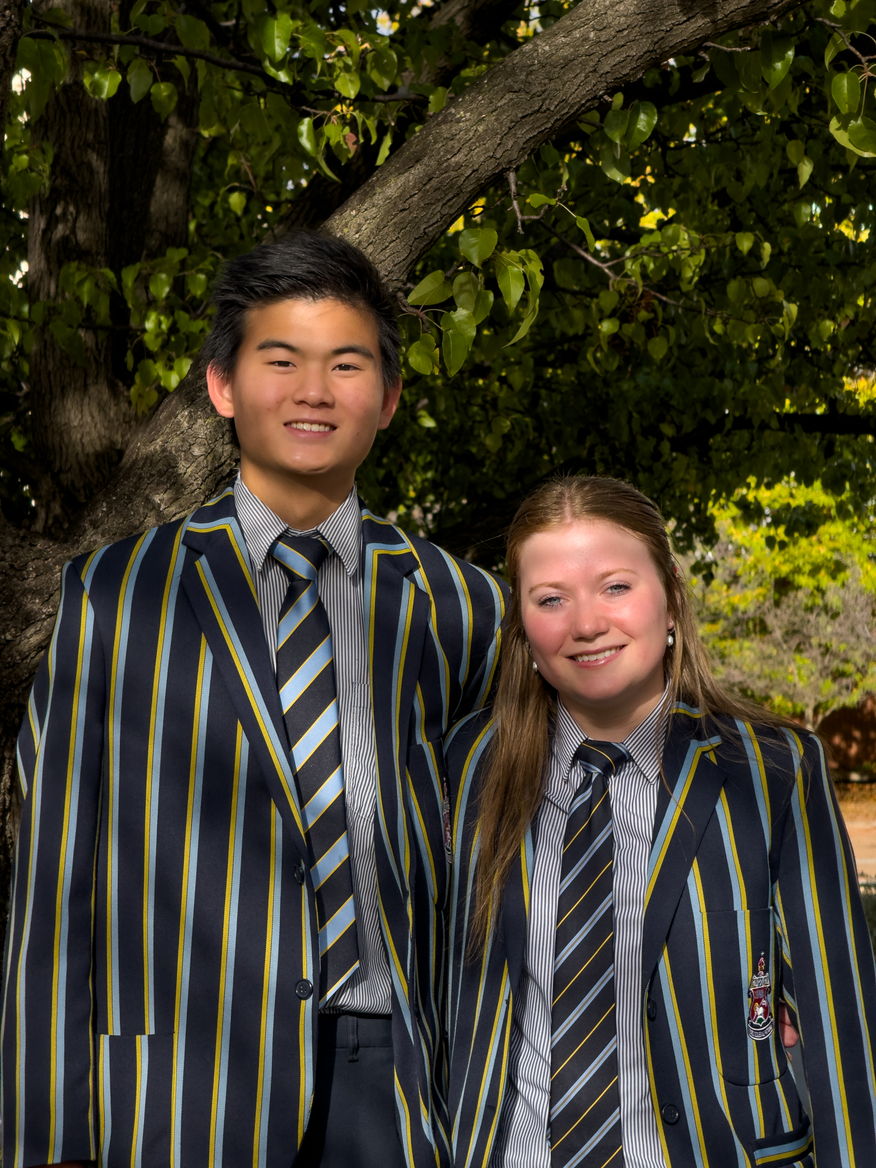 Jun and a friend in school blazers under a tree